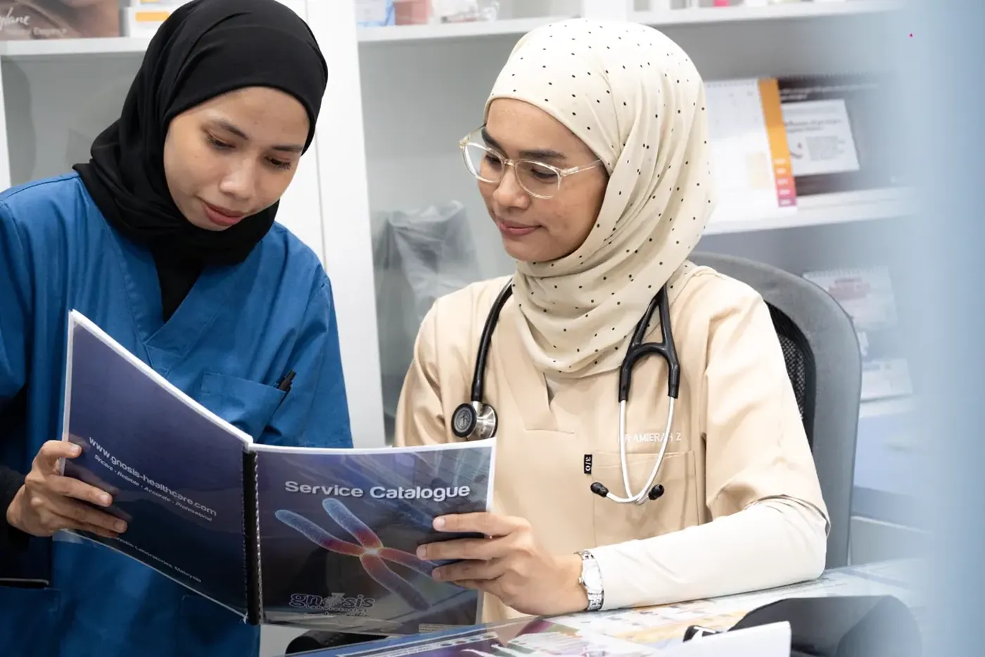 Doktor menyemak keputusan saringan kesihatan bersama pesakit di UNI Klinik Bandar Sunway